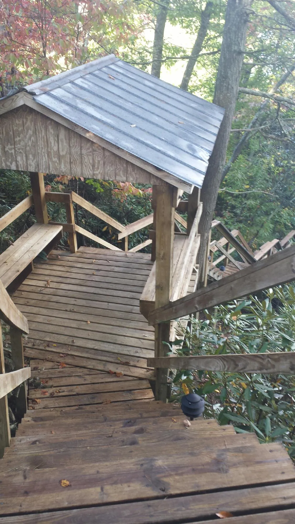 Metal roofed shelter over wooden steps on a wooded walkway — Skylight Repair & Installation work by our crew in Scotrun