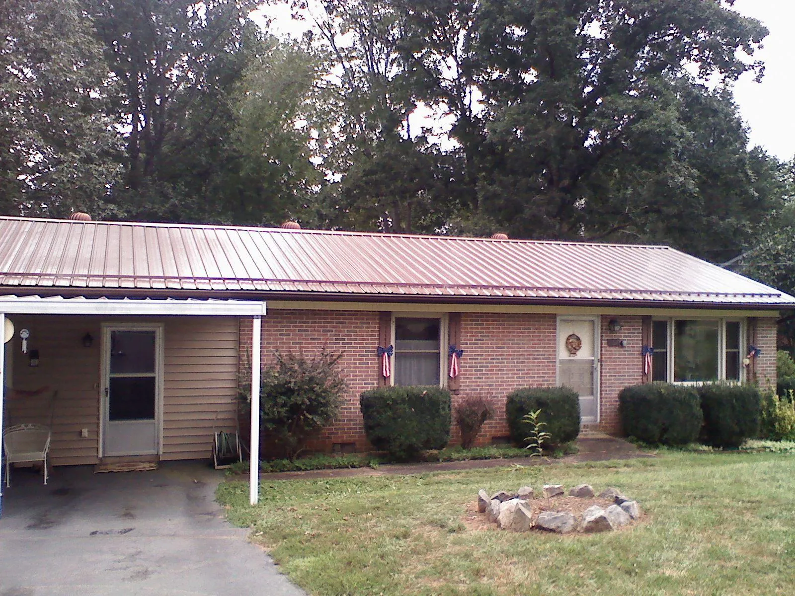 Bronze metal roof and carport on a brick ranch home — Roof Repair work by our crew in Scotrun